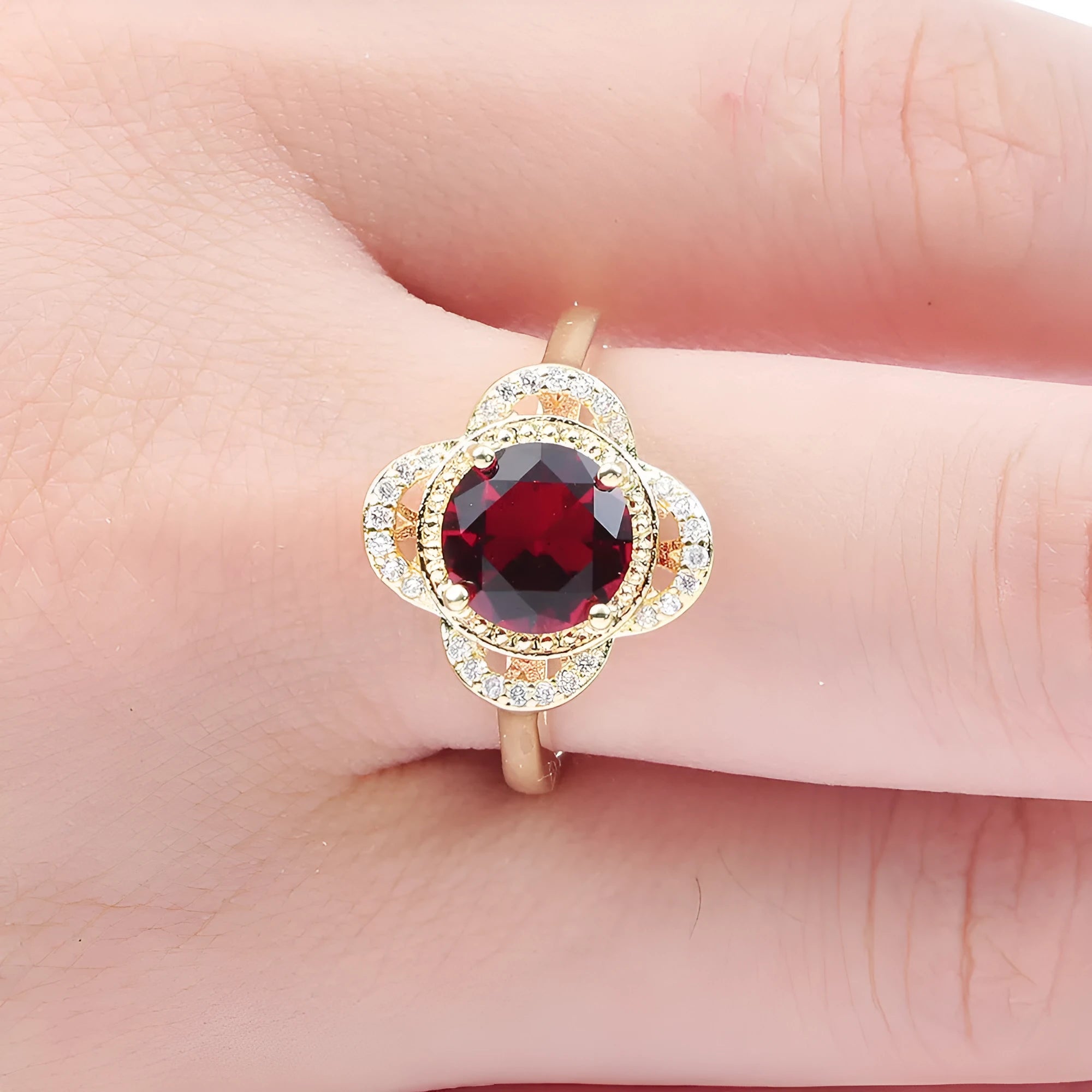 Copper ring with a fruit shape design and zircon stone inlays on a hand.