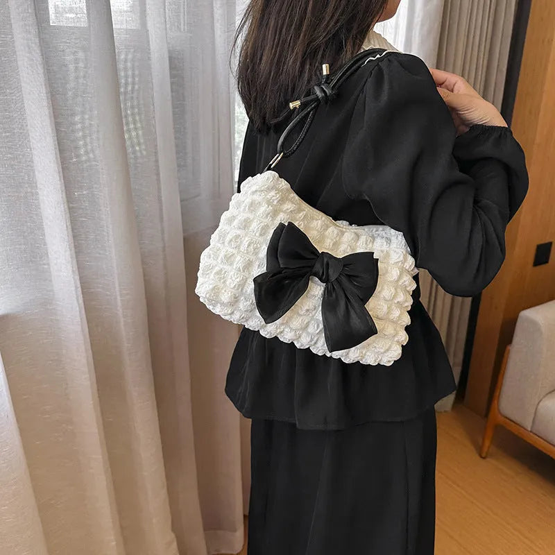 Women's black canvas one-shoulder handbag with a single strap and visible sewing thread detail
