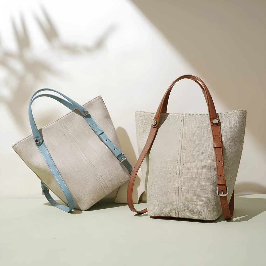 Genuine leather bucket shoulder bag in Linen Black with stitching, open outer pocket, and hand-carry strap