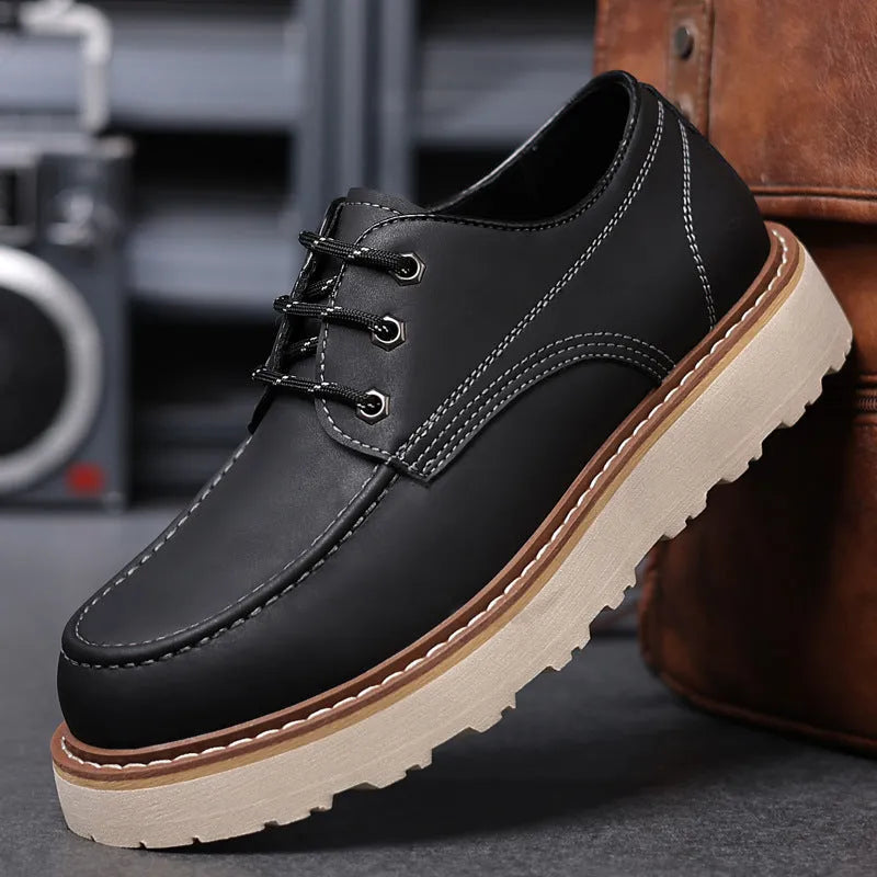Men's black low-top Martin boots with round toe and rubber sole on a neutral background