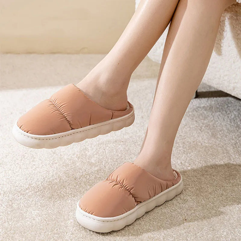 A pair of thick-soled indoor slippers with an artificial leather upper and soft plush lining, shown in a choice of colours.