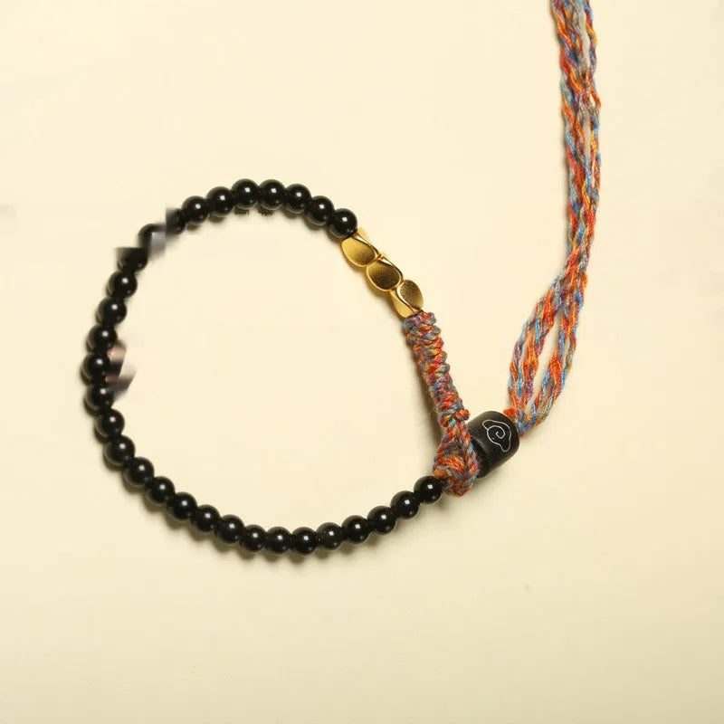 Slender dark obsidian hand-woven bracelet strap shown on a wrist