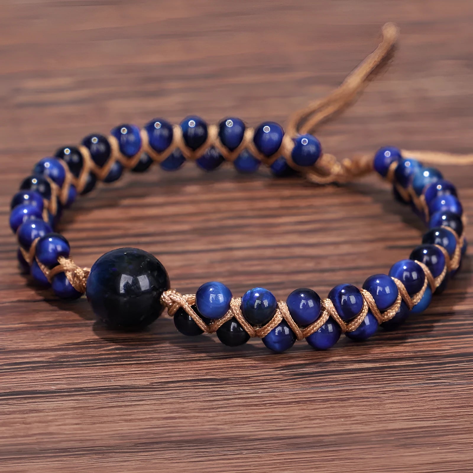 Close-up of a handmade woven bracelet with geometric tiger eye beads on an adjustable band.