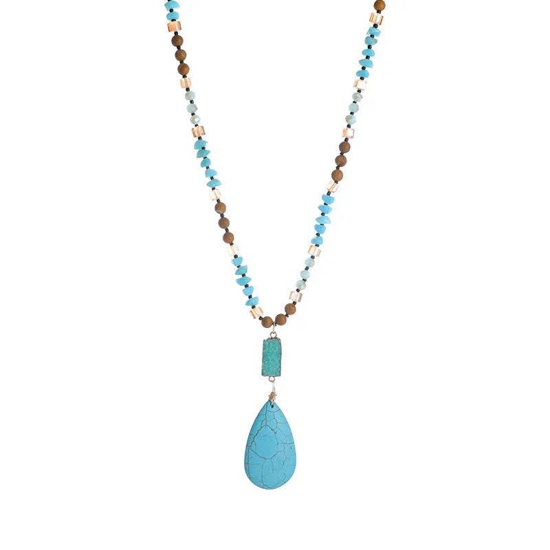 Turquoise blue large water drop pendant on a long mixed-material bead necklace.