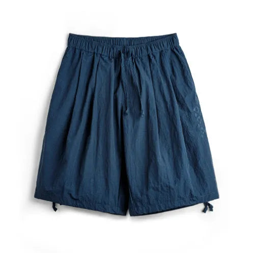 Prussian blue men's nylon loose beach shorts with embroidery on knee-length leg.