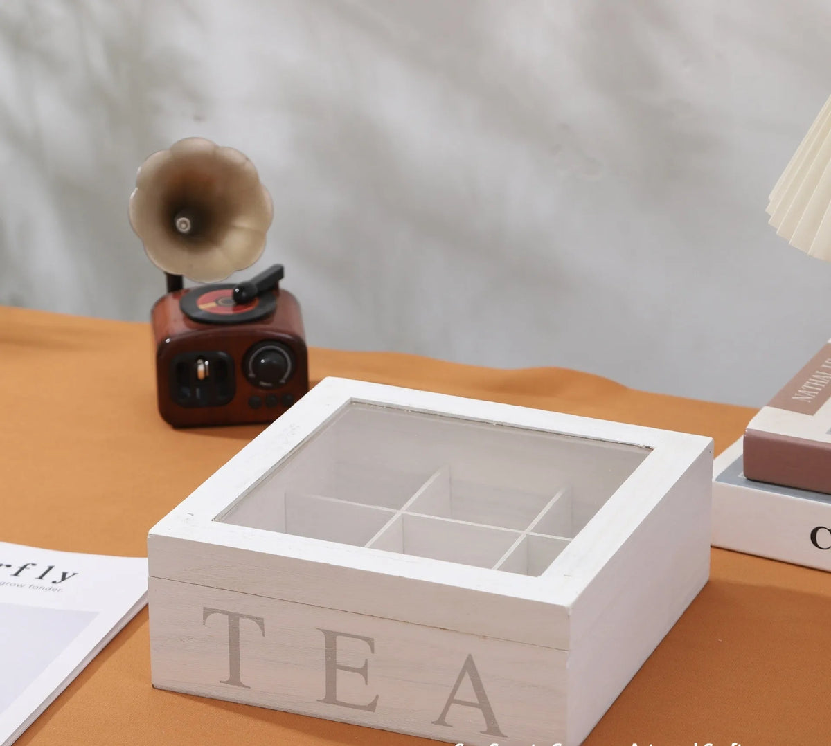 White wooden multi-grid coffee storage box with transparent cover on a desk