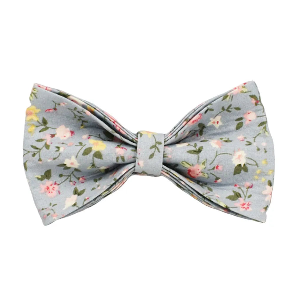 Blue floral pattern dog collar with matching leash, bow tie, vest and waste bag accessories on white background