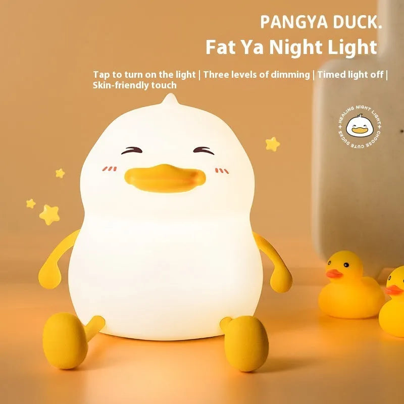 Chubby silicone rechargeable night light on a desk, showing soft glow and touch-sensitive surface.