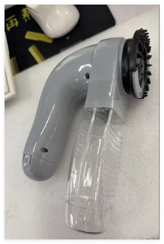 Grey handheld electric pet hair remover vacuum brush with soft rubber head.