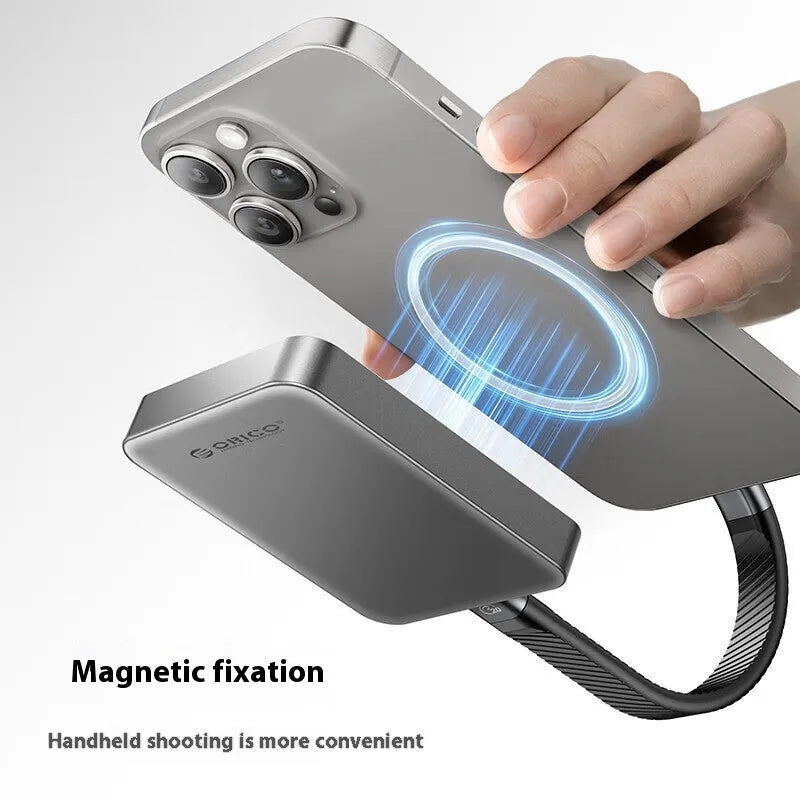 Grey magnetic mobile solid state drive with attached magnetic ring and USB C cable on a white surface.