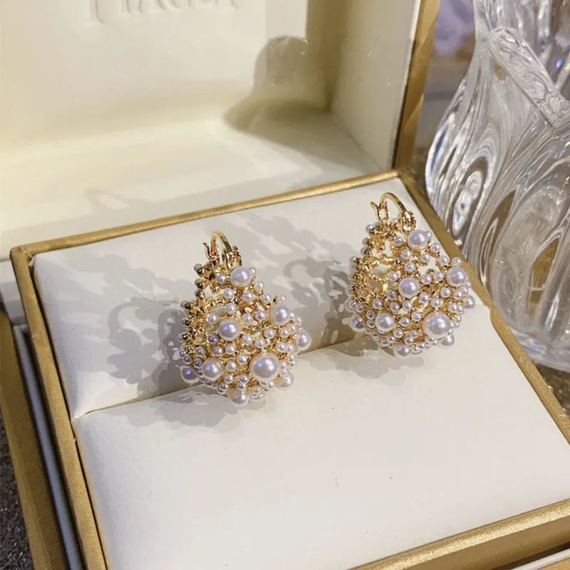 Gold-coloured copper flower basket earrings with small pearl-inlaid beads.