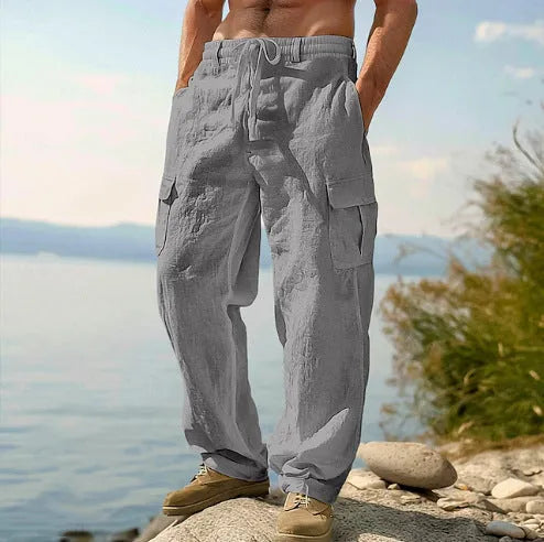 Men's loose-fitting cotton wide-leg trousers in light army green colour laid flat.