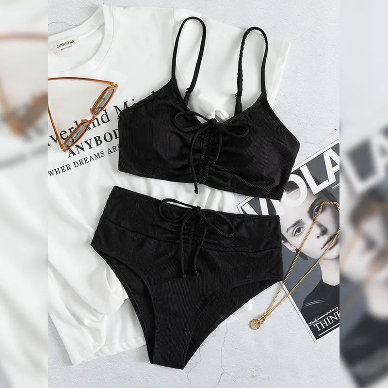 Black women's bikini swimsuit with high waist shorts and a sleeveless top on a mannequin.