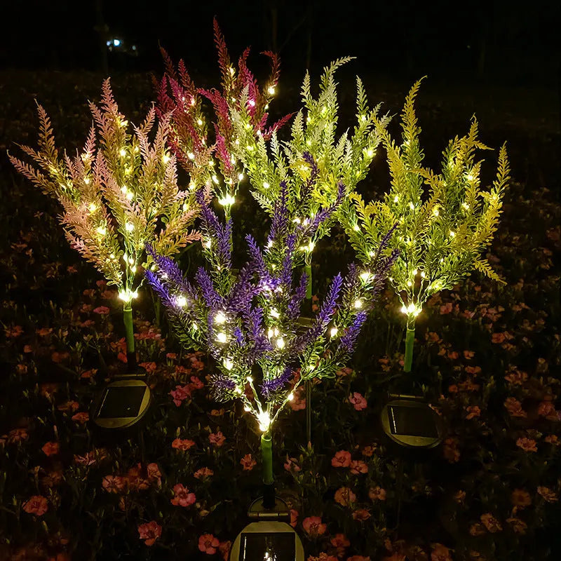 74cm tall solar-powered lavender-shaped LED garden light with stainless steel stem in a flower bed.