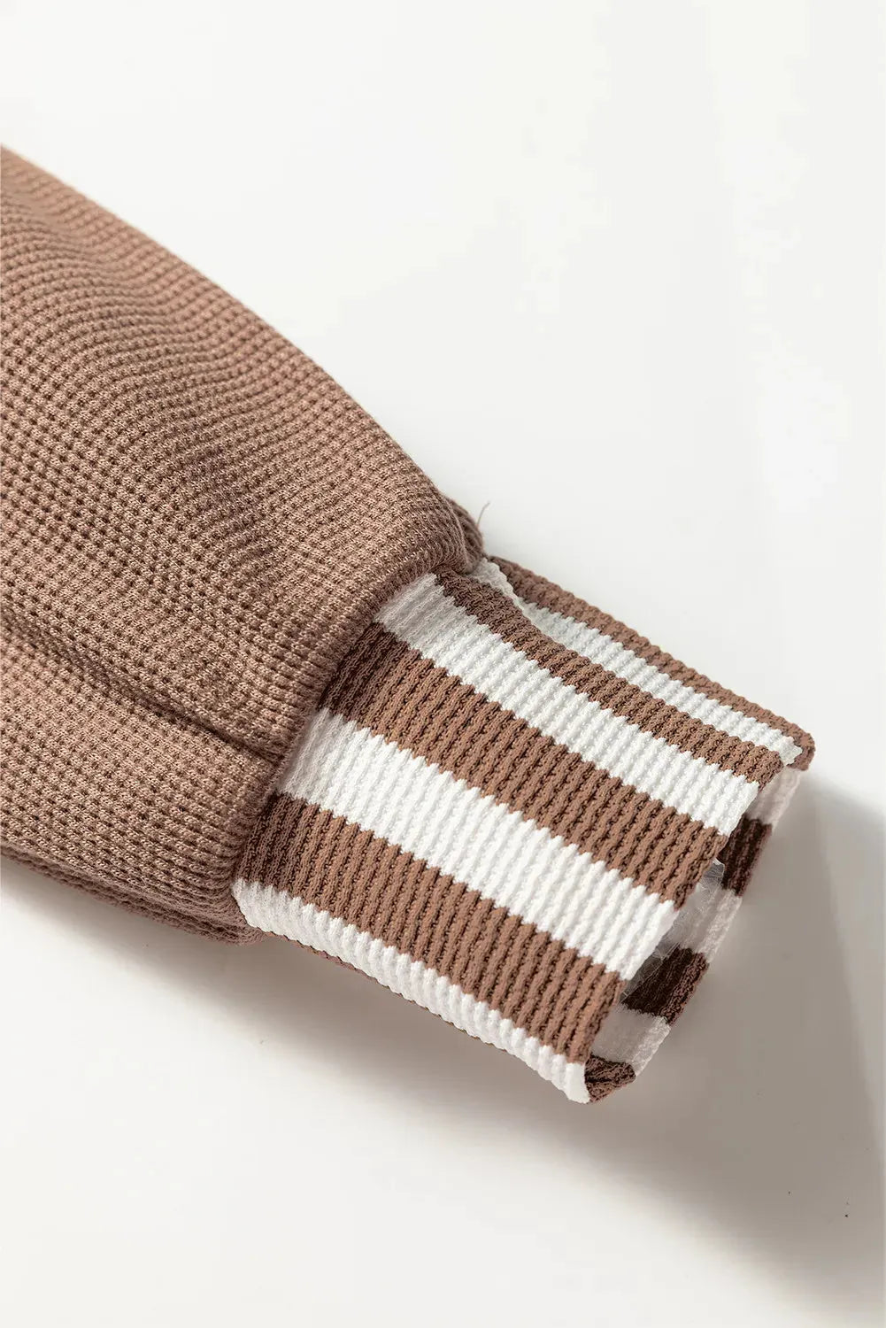 Straw yellow hoodie with waffle texture and striped patchwork design, showing front drawstring and button neck.