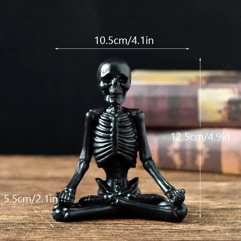 A detailed resin desktop ornament of a yoga-pose skeleton skull in black and white colour options.