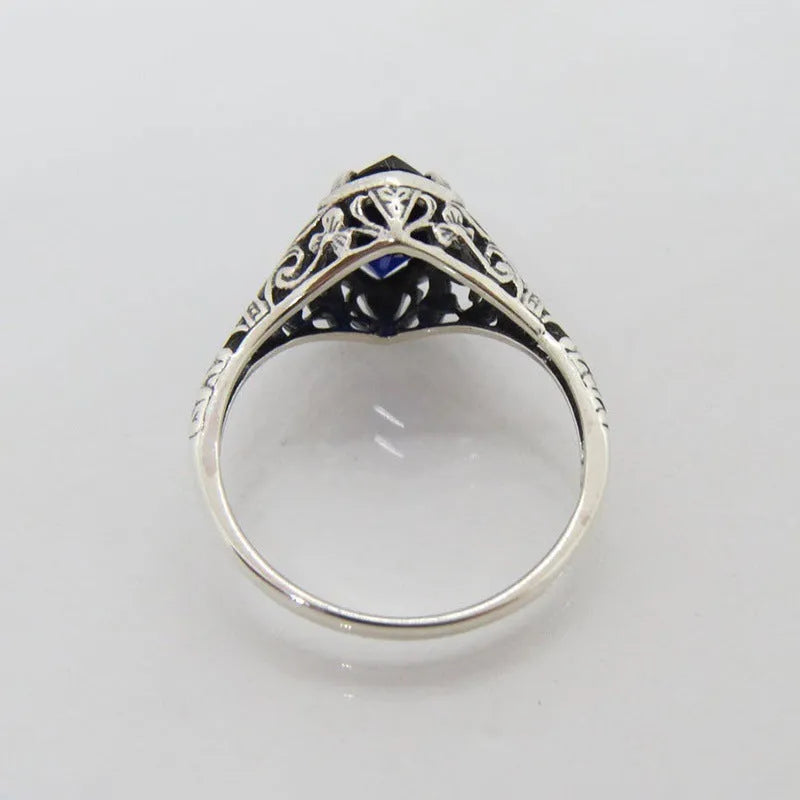Silver geometric hollow alloy women's ring on a grey background
