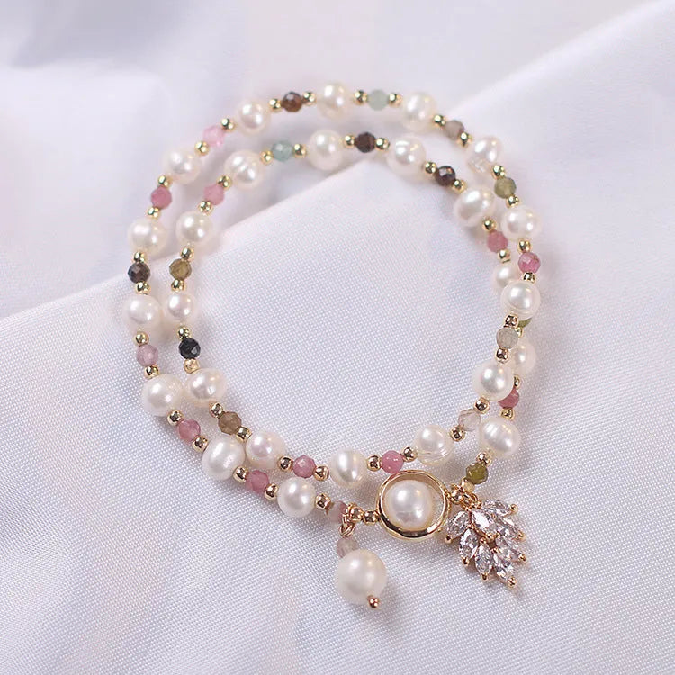 Women's double layer Strawberry Quartz crystal bracelet with Lucky Cat charm and red cat's eye flowers.