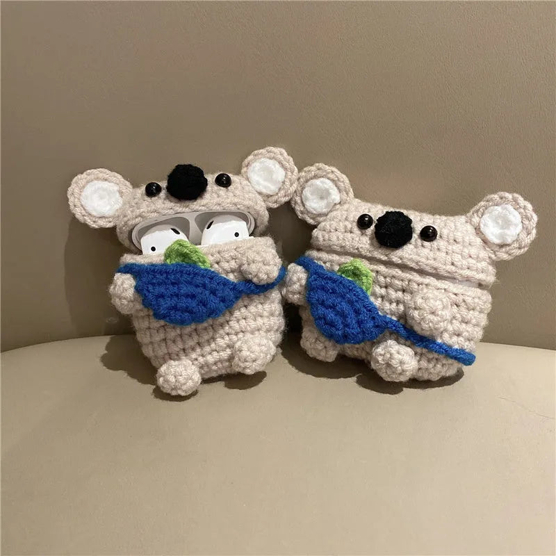 Hand-knitted grey koala bear backpack case for Apple AirPods on a wooden table.