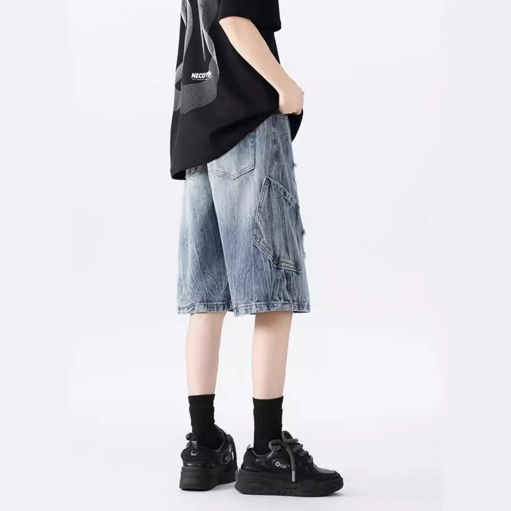 Men's loose fit distressed denim shorts in black vintage style with ripped detailing
