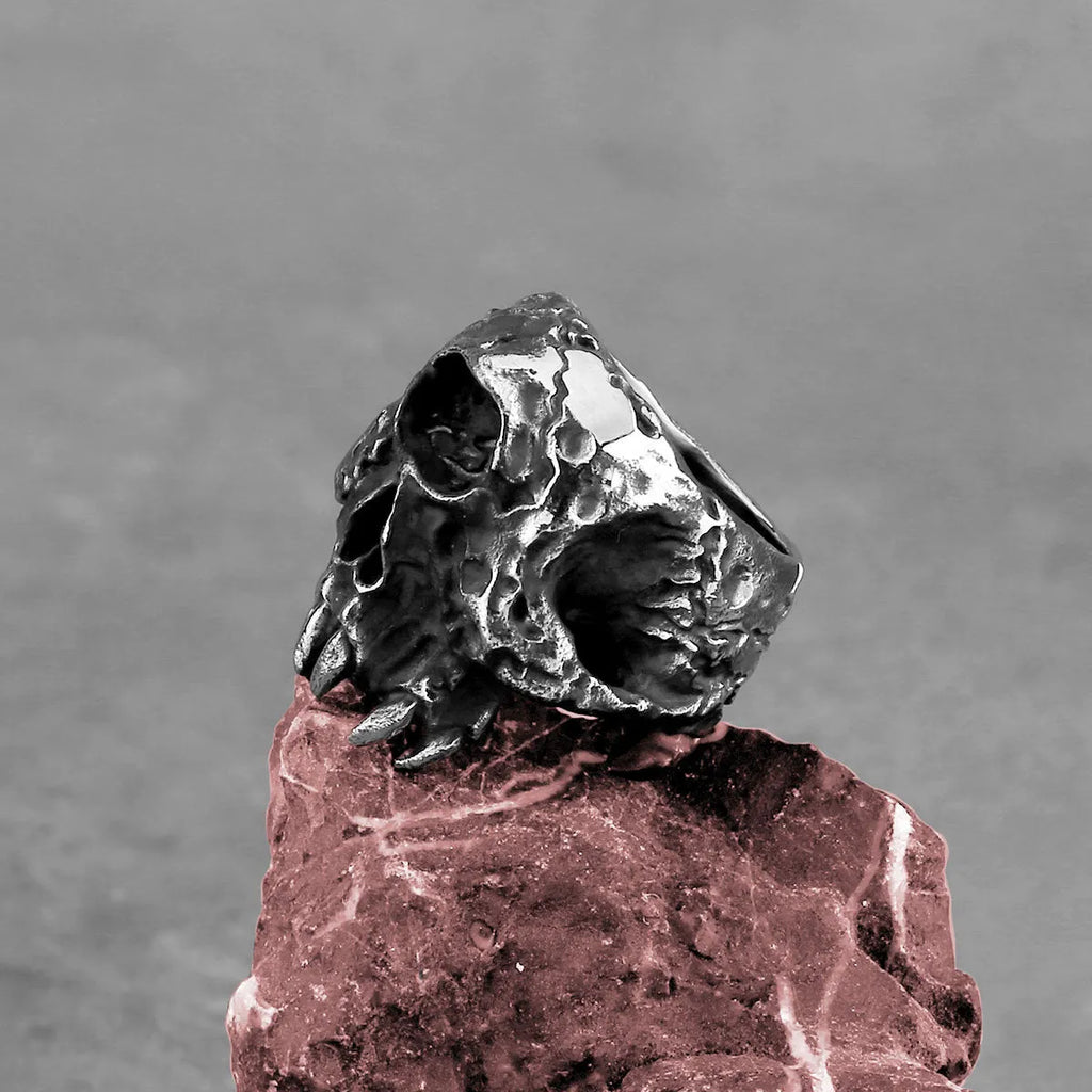 Silver-coloured alloy ring with a detailed one-eyed skull design on a finger.