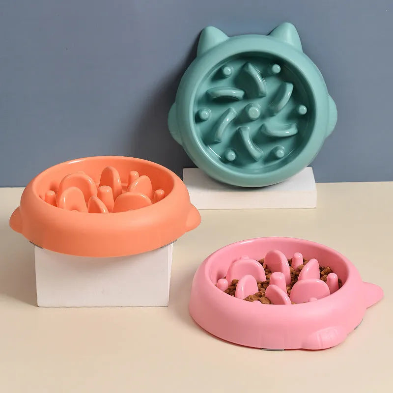 Bone-shaped slow feeder dog bowl with maze pattern in green, pink, or orange colours