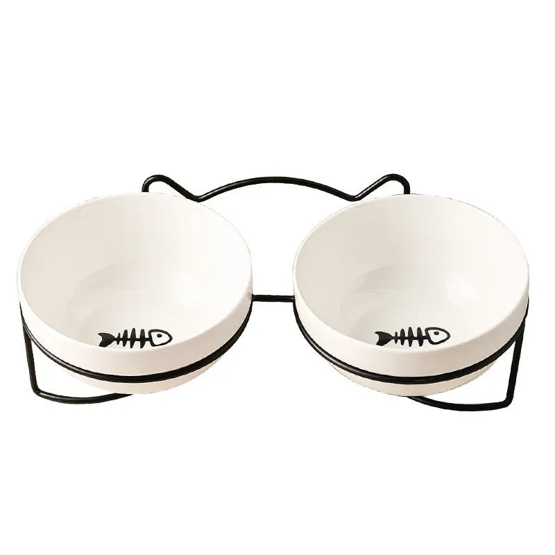 White ceramic cat bowl with paw print design in a black iron cat-ear frame.