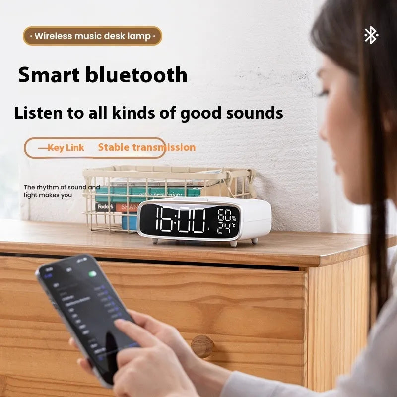White wireless charging Bluetooth speaker alarm clock with LED night light on bedside table