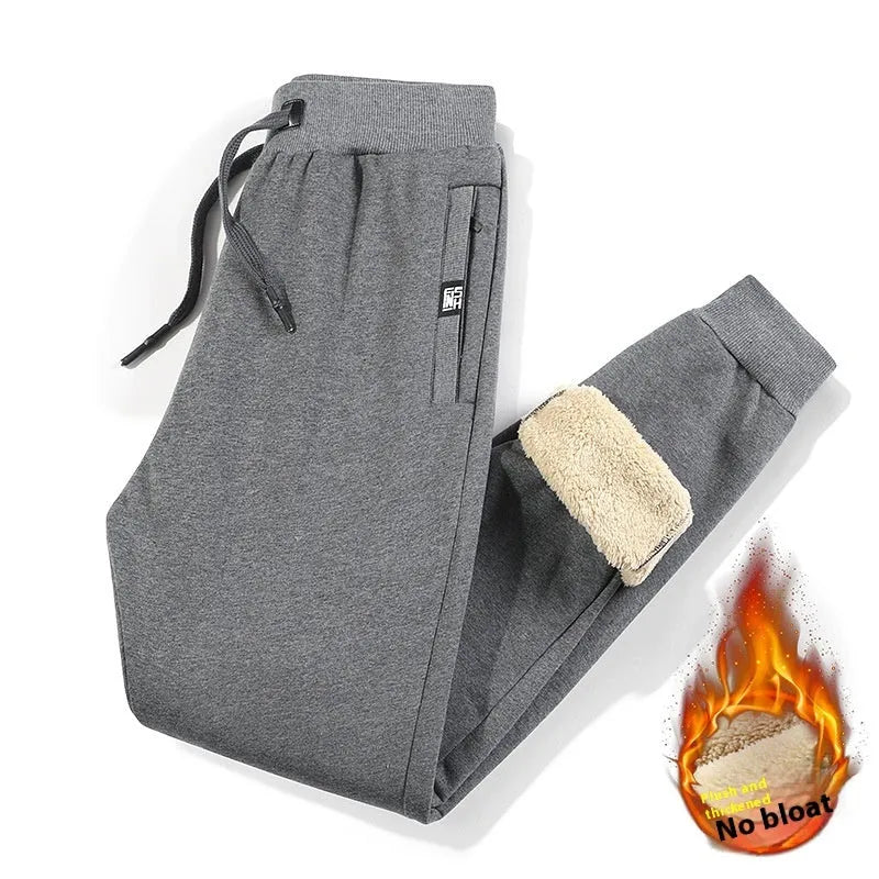 Men's grey fleece-lined cotton track pants with an elasticated waistband and drawstring, shown in an oversized fit.