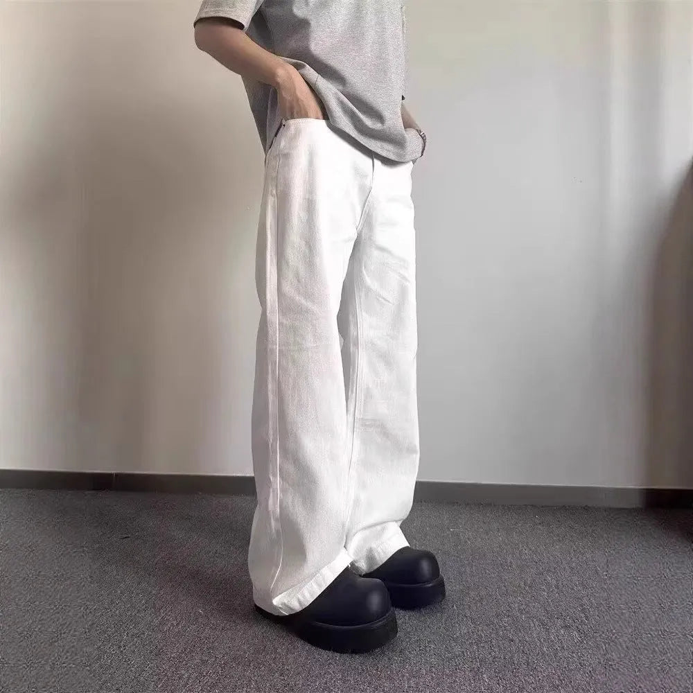Men's loose straight leg white cotton denim jeans on a hanger.