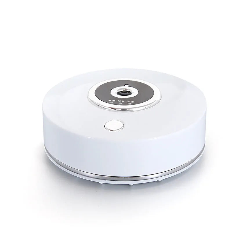 White plastic car aromatherapy diffuser with USB cable and anti-slip pad on a car dashboard.