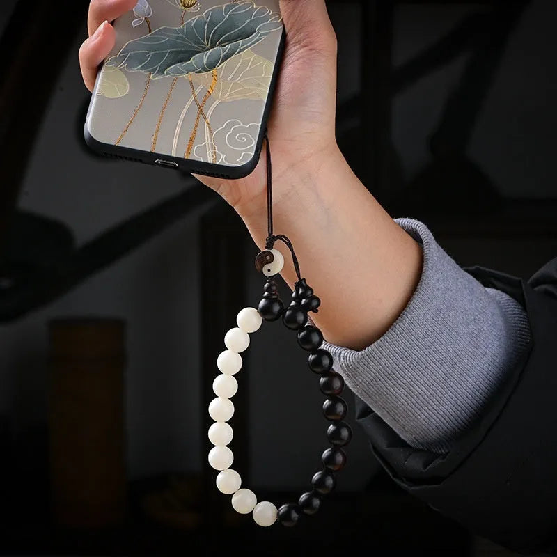 Close-up of a white retro eight-diagram-shaped Bodhi bead bracelet with 11mm beads on a black background.