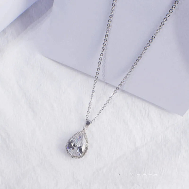 Water drop shaped geometric pendant necklace with rhinestone detailing in rose gold pink colour