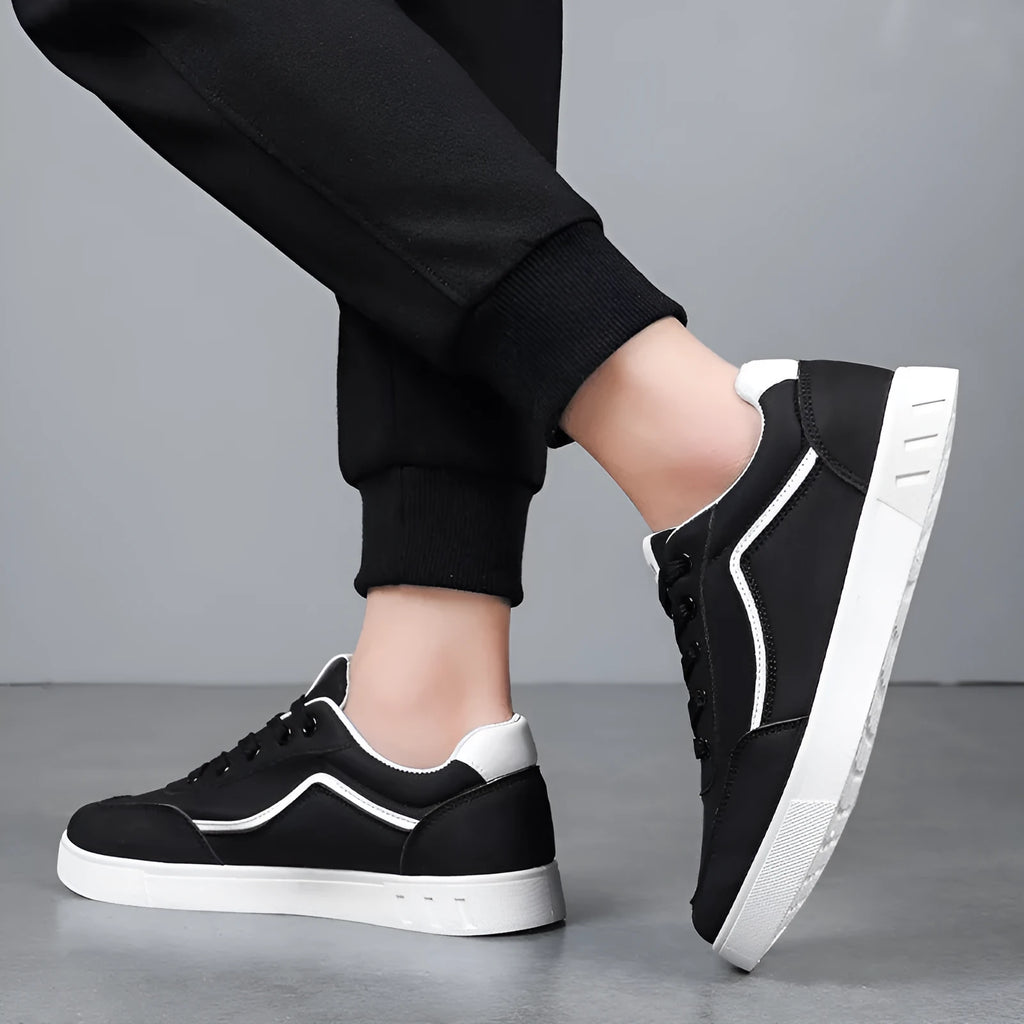 Korean style low top board sneakers in black with white stitching and a flat rubber sole.