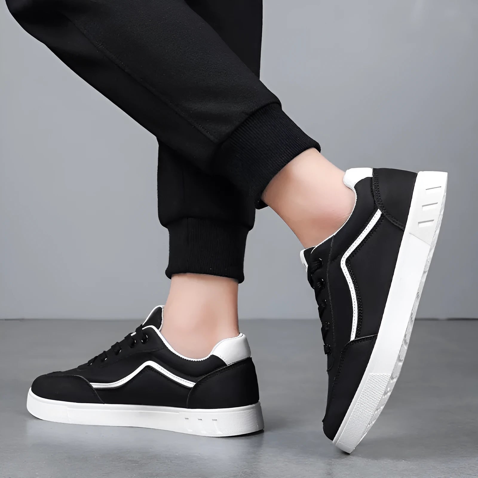 Korean style low top board sneakers in black with white stitching and a flat rubber sole.