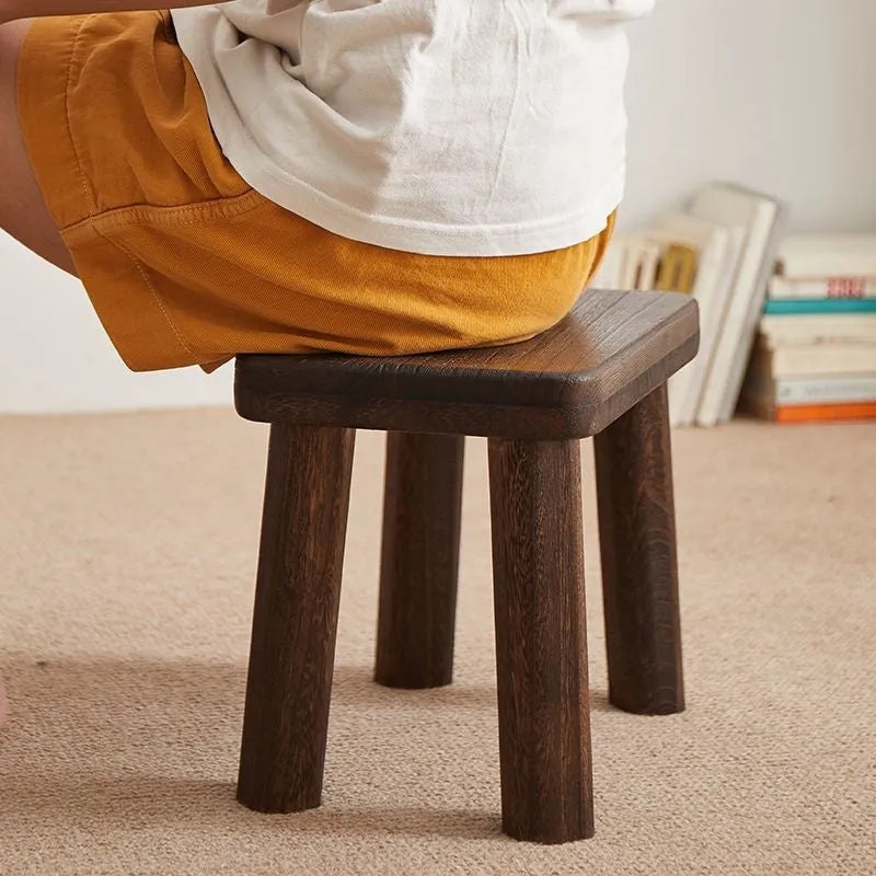 Solid wood distressed finish changing stool with bracket structure legs.