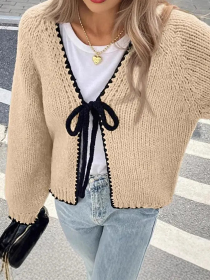 Grey lace-up sweater cardigan with long sleeves and crocheted flower decoration on the front.