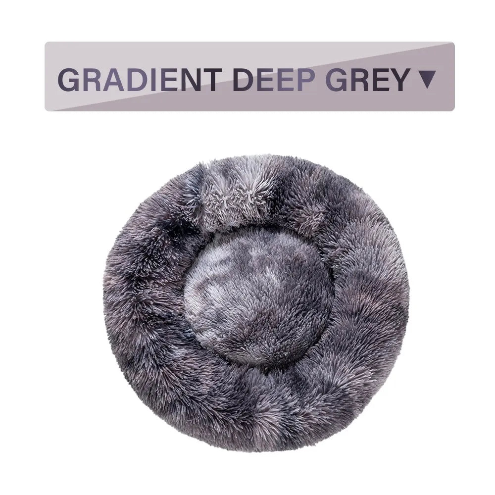Fluffy donut-shaped dog bed in light grey plush material, showing raised rim and central cushion.