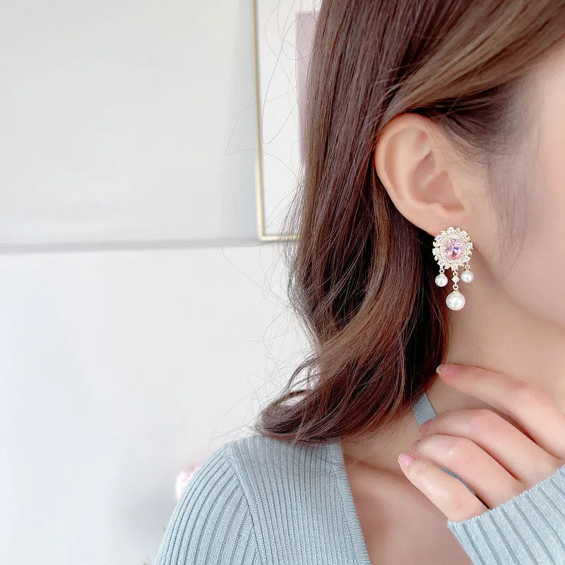 Oval geometric earrings with zircon inlay, pearl details, and tassel design in light purple colour