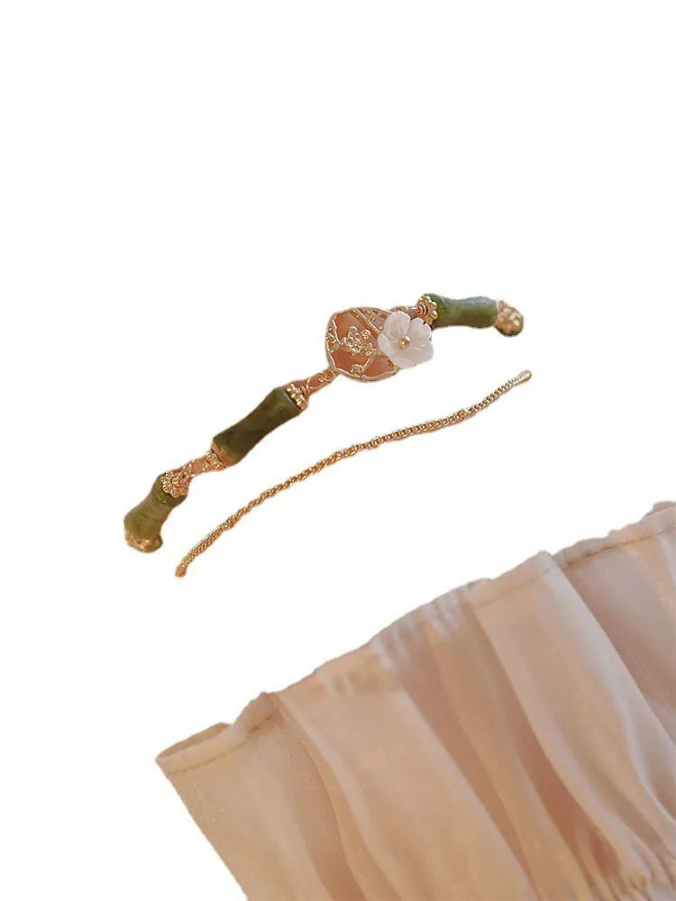A green olivine stone bracelet with double layers, an Olive Branch charm, and Twin Bells of Ireland pendant.