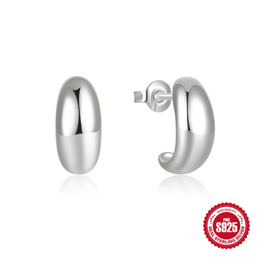 A single pair of glossy C-shaped sterling silver stud earrings on a white background.