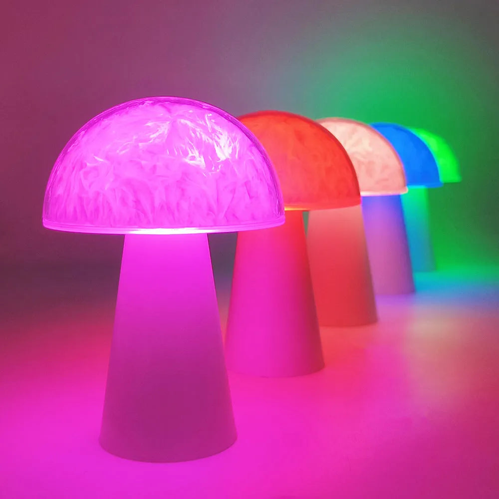 Small white mushroom-shaped night light with remote control on a wooden table.
