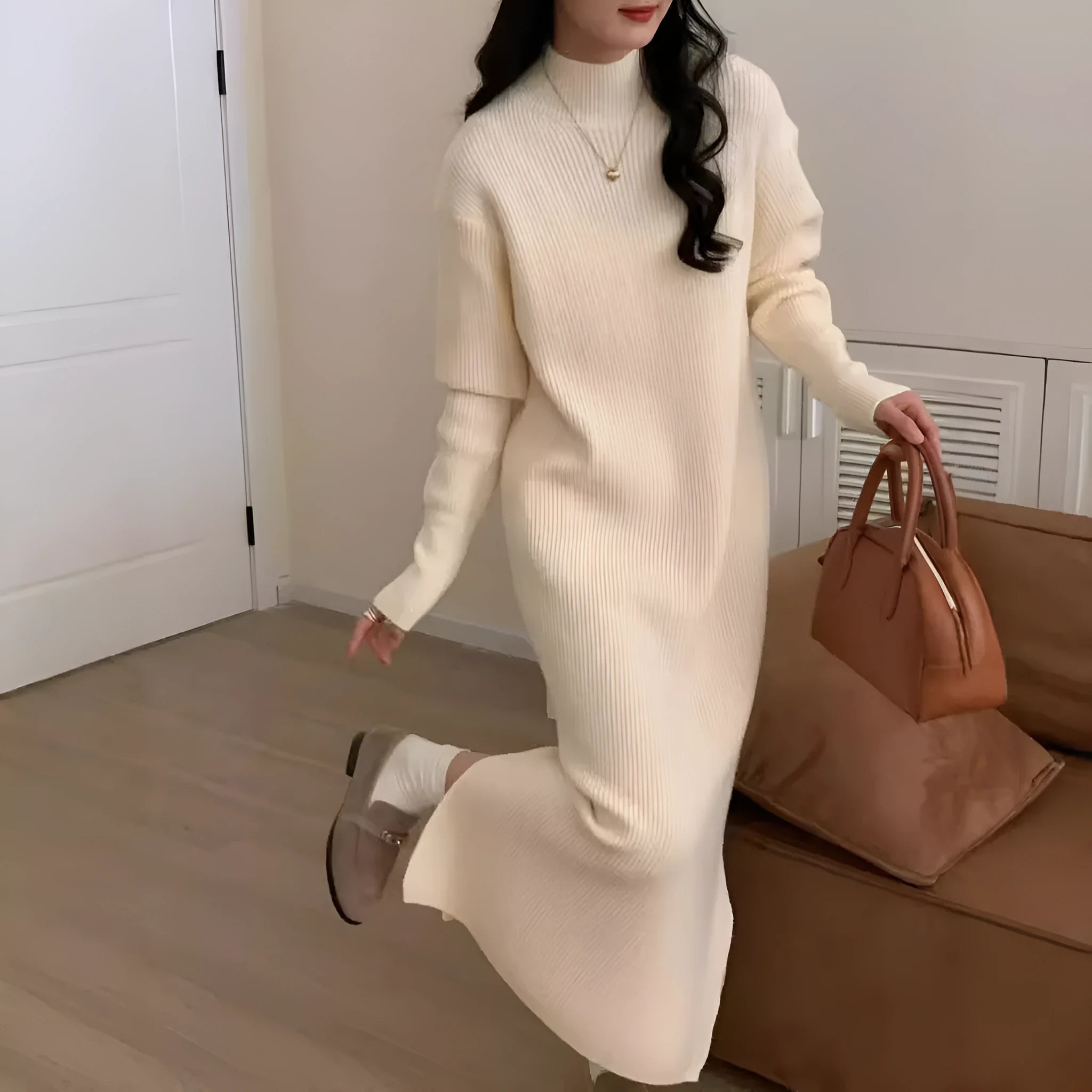 A woman wearing a beige turtleneck knitted dress with long sleeves and a high waist.