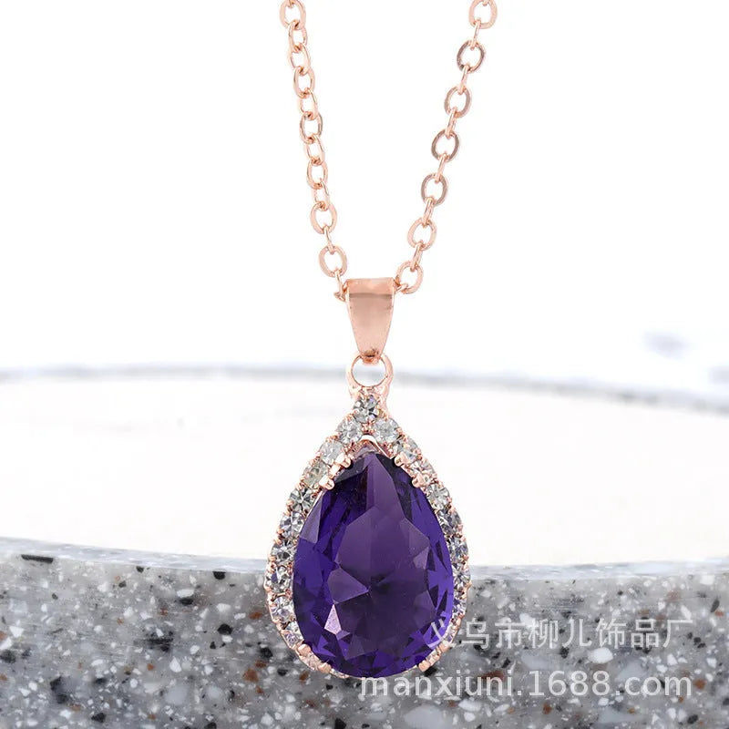 Close-up of a women's pink rose gold drop necklace with geometric rhinestone patterns on an alloy setting.