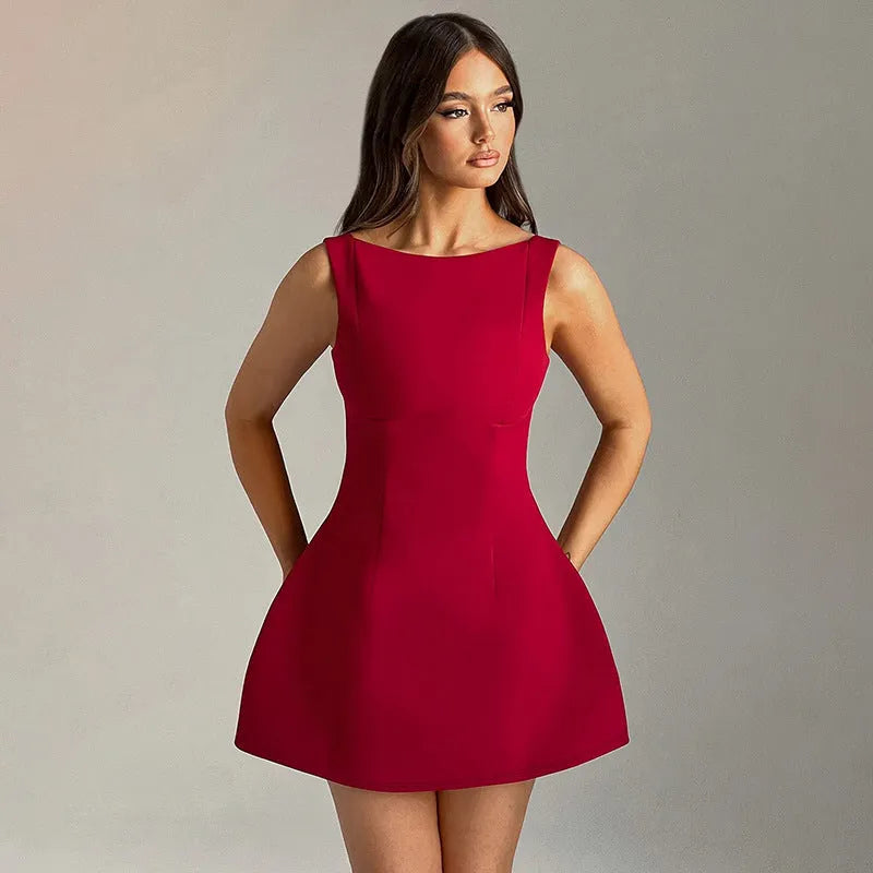 Black backless sling dress with slim fit and short skirt on a model.