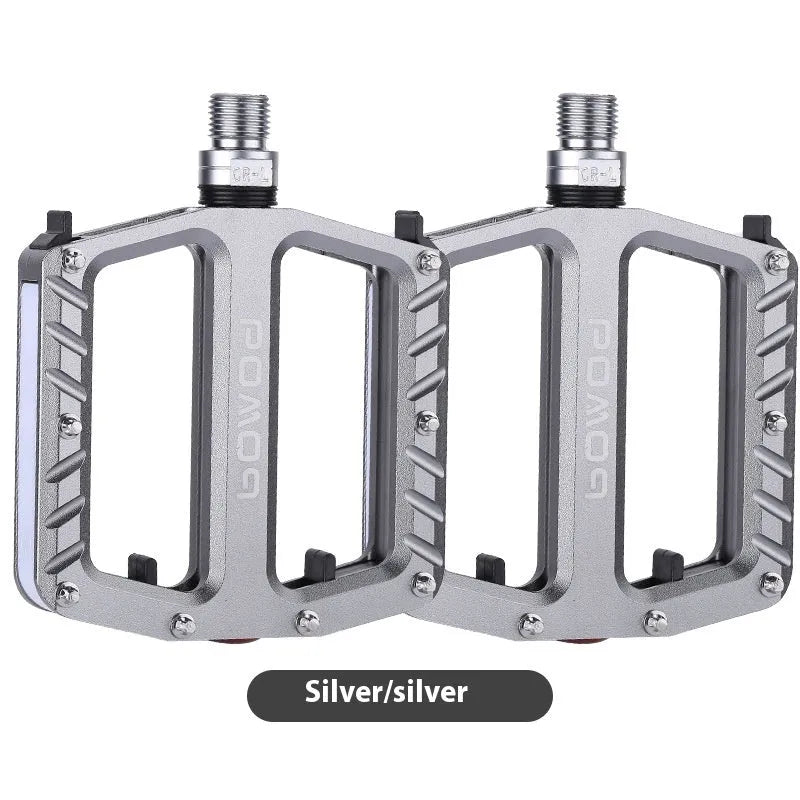 Aluminium alloy bicycle pedals with built-in LED lights in purple, black, titanium, red, and gold colour options.