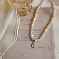 Adjustable French vintage style pearl necklace with geometric links on a white background.