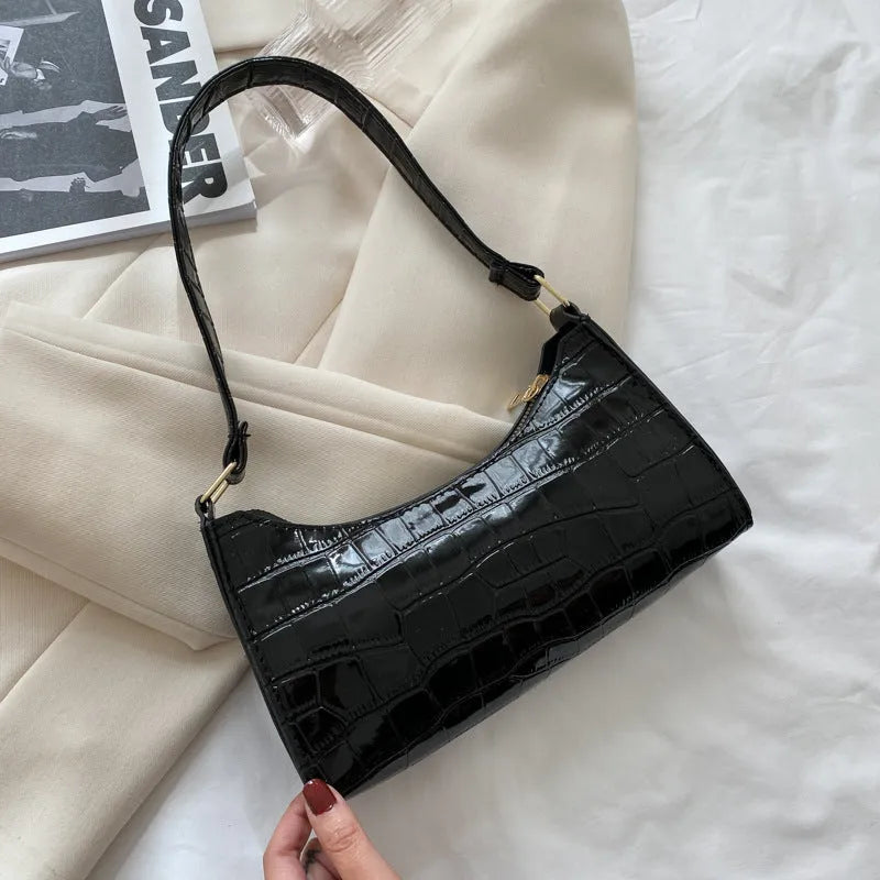 Women's small PU underarm bag with crocodile pattern, belt detail, and zipper closure in beige
