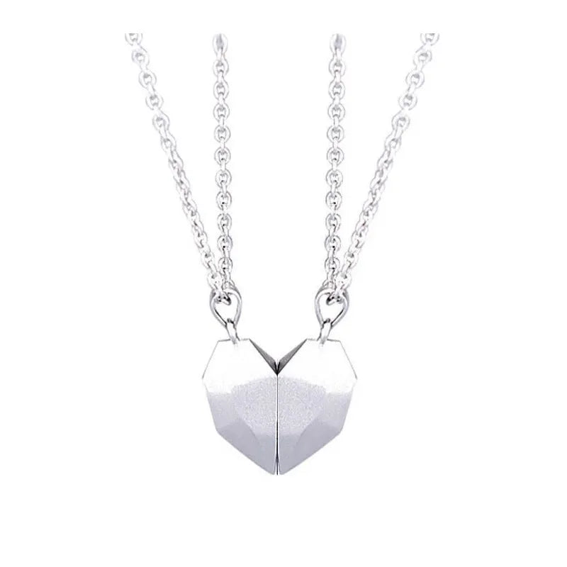 Gold-plated magnetic faceted heart pendant necklace in black and white on display