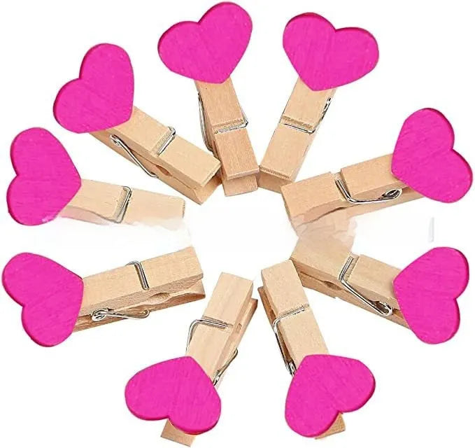 Set of five handmade solid wood heart-shaped clips in red, rose red, and white colours on a plain background.
